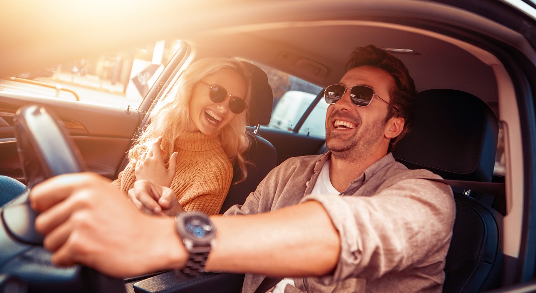 Un homme et une femme souriant dans un véhicule Mitsubishi