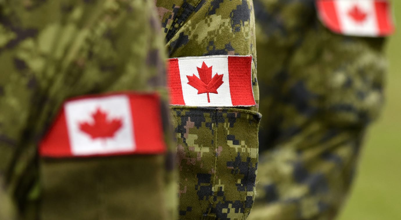 Écussons du drapeau canadien sur la manche de l'uniforme militaire de trois soldats
